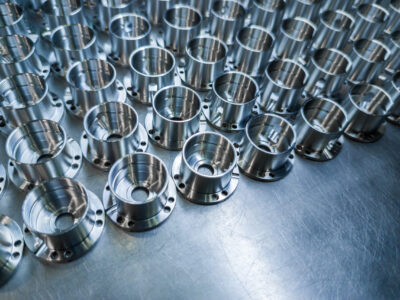 Shiny metal aerospace parts after cnc machining on steel surface with selective focus, industrial background